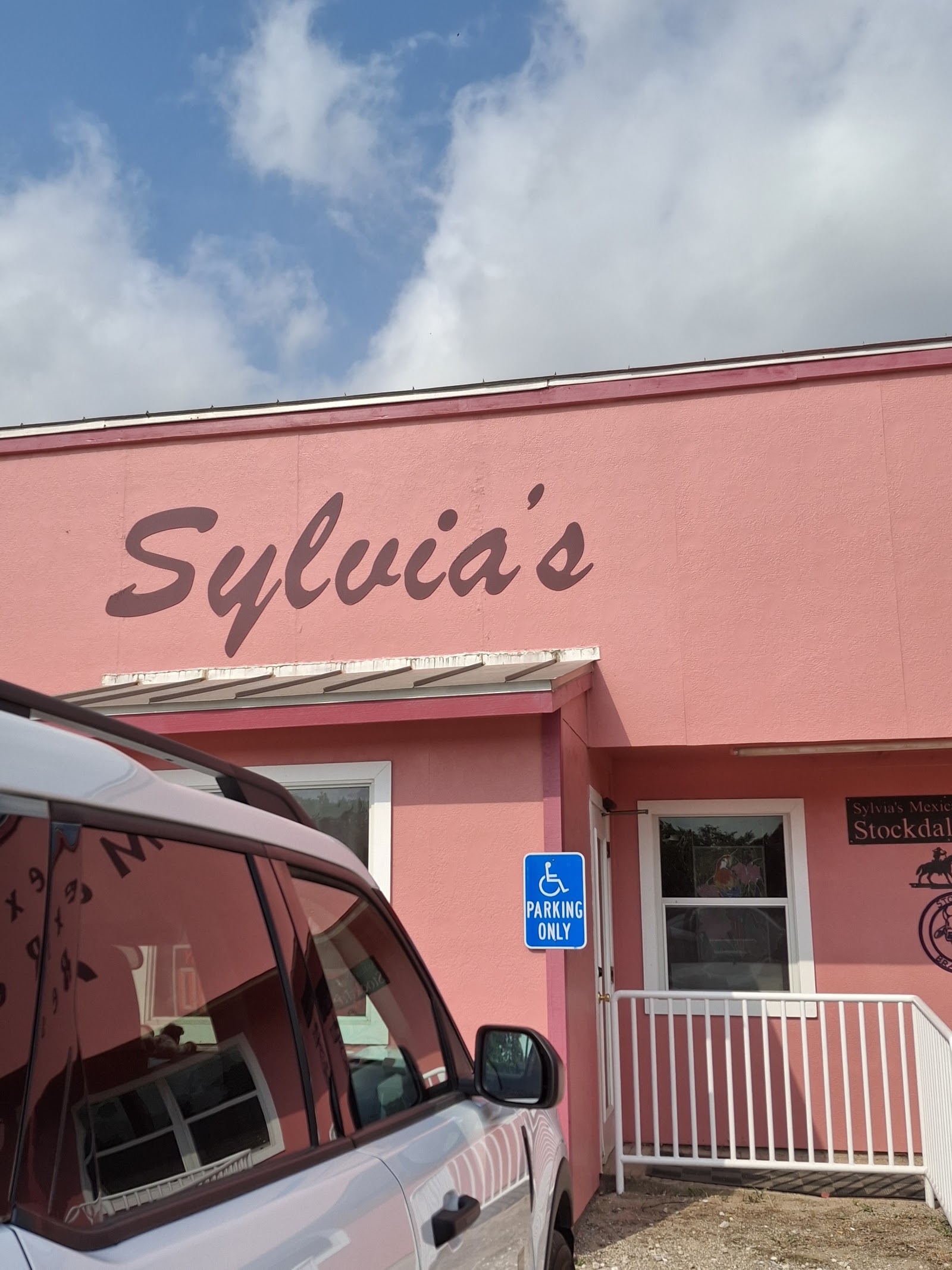 Close-up of the pink Sylvia's Mexican Restaurant sign and entrance in Stockdale, Texas