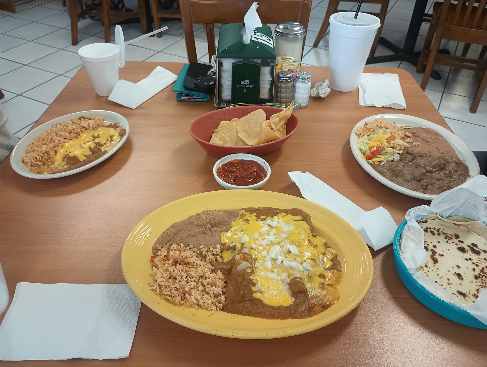 Table spread of cheese enchilada plates, rice, beans, chips and homemade tortillas
